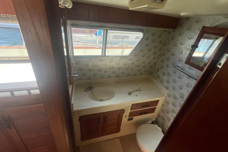 Slide: The Image of 1981 Tollycraft 48 Motor Yacht bathroom with sink, toilet, and window view. - 29
