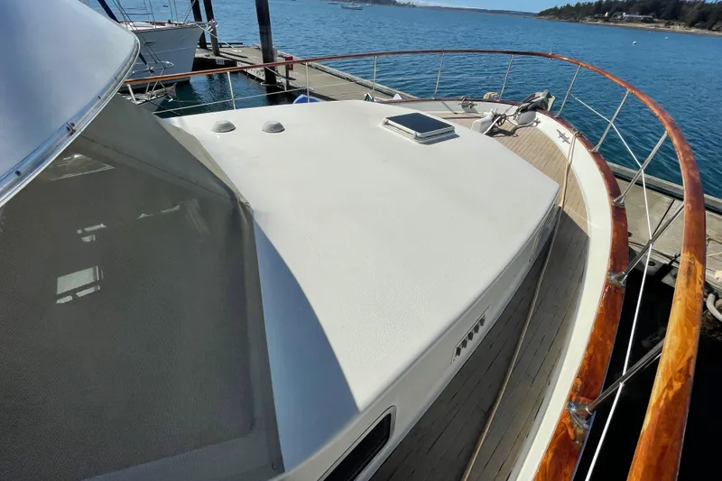 Slide: The Image of 1981 Tollycraft 48 Motor Yacht docked, showcasing the spacious deck and sleek design. - 6