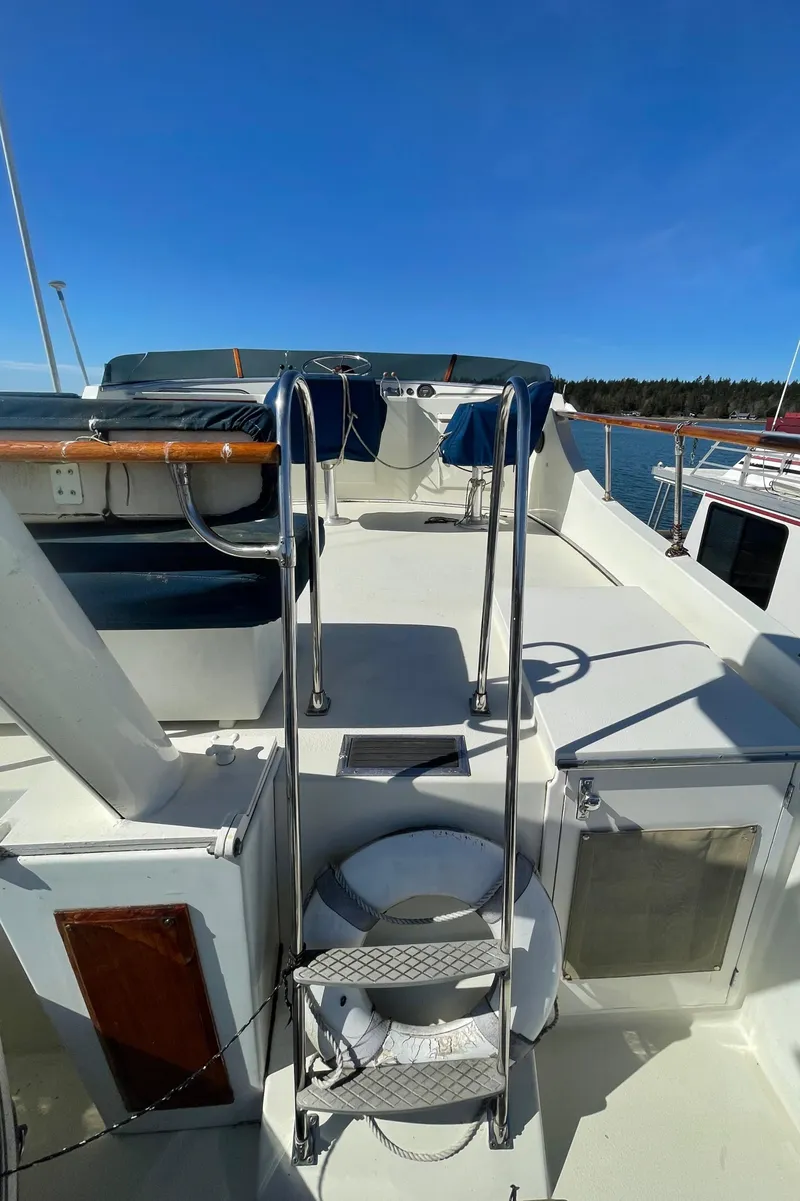 Slide: The Image of 1981 Tollycraft 48 Motor Yacht deck with ladder and seating area. - 8
