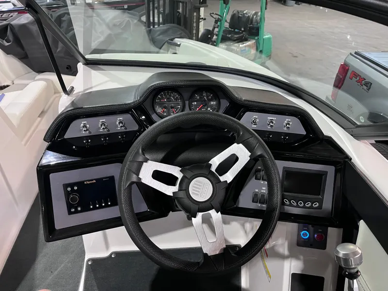 Slide: The Image of 2023 MasterCraft NXT21 boat dashboard with steering wheel and control panel. - 11