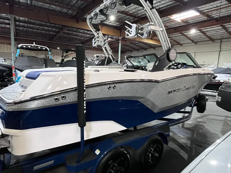 Slide: The Image of 2023 MasterCraft NXT21 boat in showroom, featuring sleek design and modern equipment. - 2