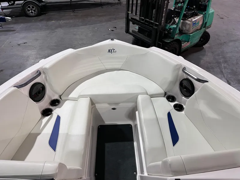 Slide: The Image of 2023 MasterCraft NXT21 boat interior with white seating and cup holders. - 9