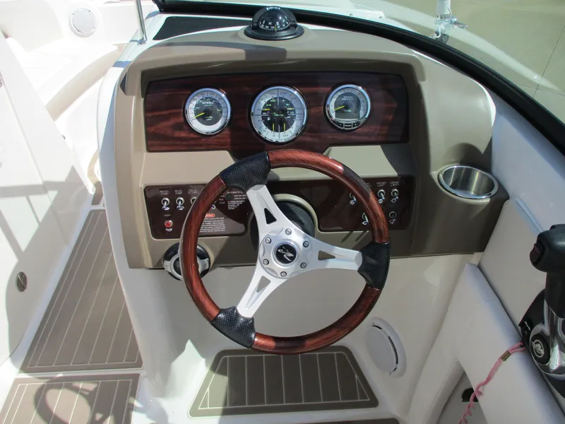 Slide: The Image of Dashboard of a 2012 Sea Ray 220 Sundeck boat with wooden steering wheel. - 10