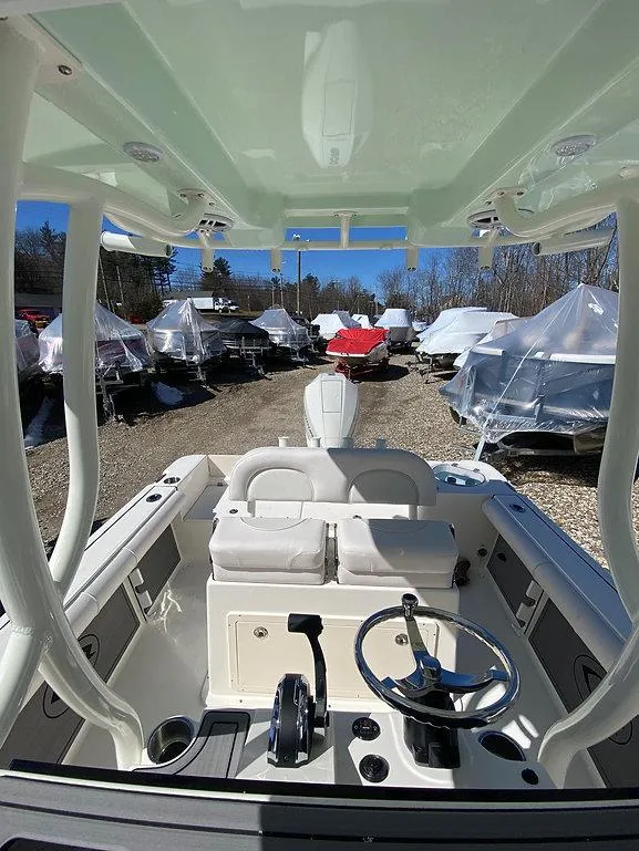 Slide: The Image of 2023 Sea Born LX 22 LE boat interior with helm, parked among covered boats. - 6