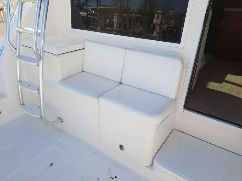 Slide: The Image of 2008 Tiara Yachts 3900 Convertible boat seating area with ladder and window. - 14
