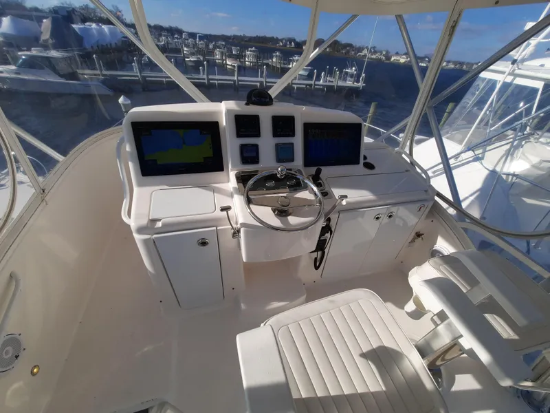 Slide: The Image of 2008 Tiara Yachts 3900 Convertible helm with dual displays and marina view. - 23