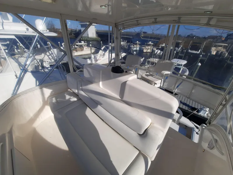 Slide: The Image of 2008 Tiara Yachts 3900 Convertible interior with white seating and marina view. - 30