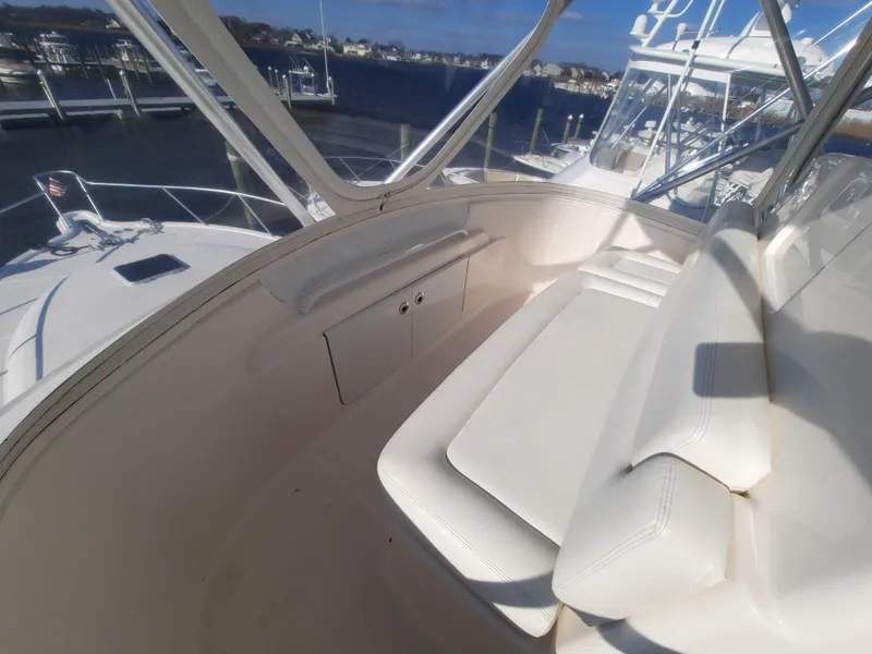 Slide: The Image of 2008 Tiara Yachts 3900 Convertible boat interior with white seating and marina view. - 33