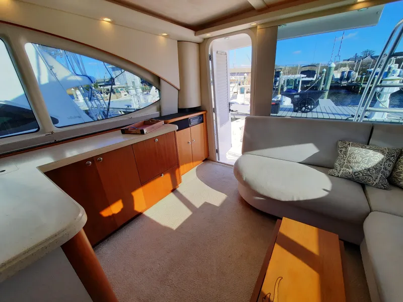 Slide: The Image of Interior of 2008 Tiara Yachts 3900 Convertible, featuring a cozy seating area and wooden cabinetry. - 37