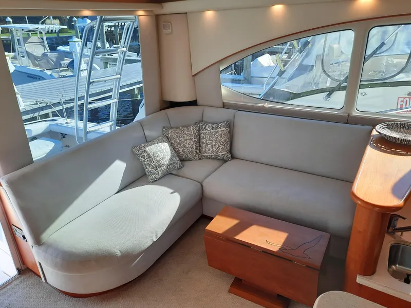 Slide: The Image of Interior of 2008 Tiara Yachts 3900 Convertible with a cozy L-shaped sofa and wooden table. - 40