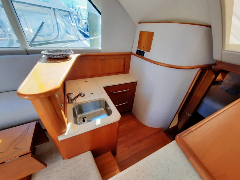 Slide: The Image of 2008 Tiara Yachts 3900 Convertible interior kitchen with sink and wooden cabinetry. - 44