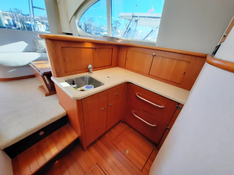 Slide: The Image of 2008 Tiara Yachts 3900 Convertible kitchen area with wooden cabinetry and sink. - 45