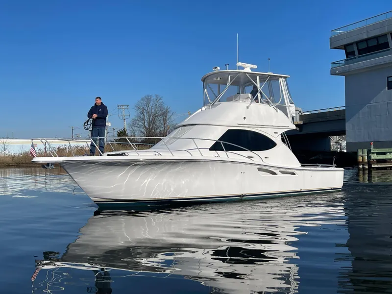 Slide: The Image of 2008 Tiara Yachts 3900 Convertible on calm water near a dock. - 5