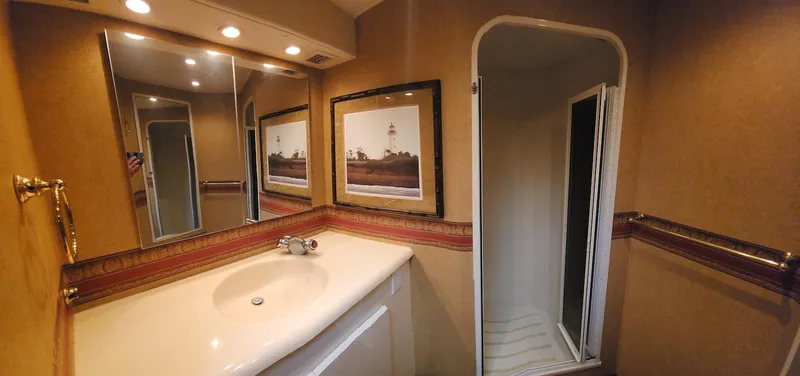 Slide: The Image of Bathroom interior of 2000 Viking 55 Convertible yacht, featuring sink, mirror, and shower. - 19