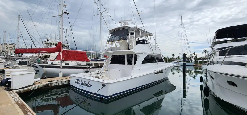 Slide: The Image of 2000 Viking 55 Convertible yacht docked in a marina, surrounded by other boats. - 3