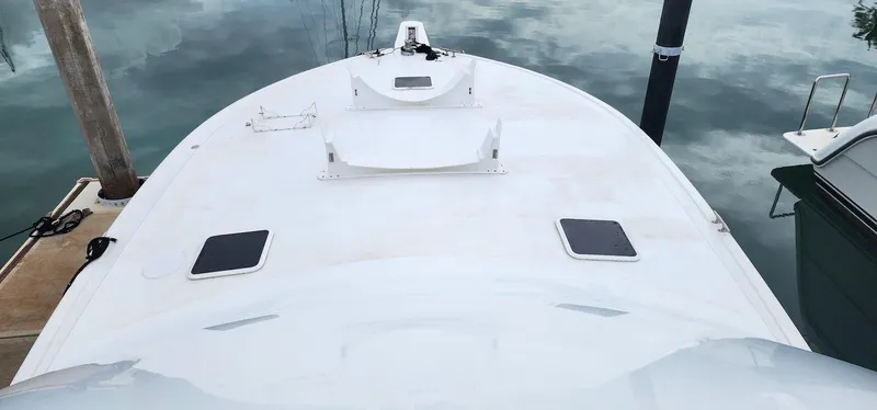 Slide: The Image of Bow view of 2000 Viking 55 Convertible yacht docked on calm water. - 5