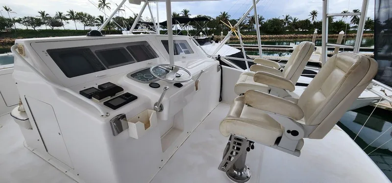 Slide: The Image of Helm of 2000 Viking 55 Convertible yacht with control panel and seating. - 6