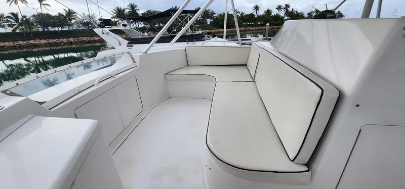 Slide: The Image of Viking 55 Convertible 2000 yacht with white seating, docked near palm trees. - 8