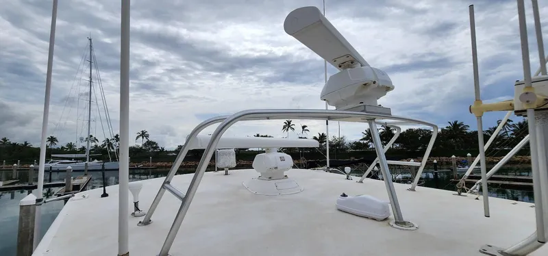 Slide: The Image of Viking 55 Convertible yacht deck, 2000 model, with radar equipment, docked under cloudy sky. - 9