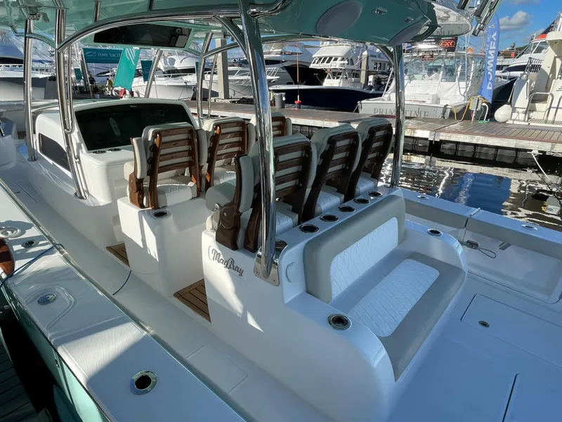 Slide: The Image of 2025 Mag Bay 43 Center Console boat with luxurious seating at a marina. - 16