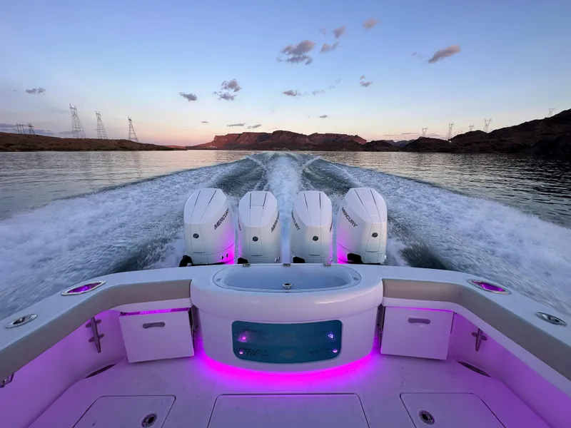 Slide: The Image of 2025 Mag Bay 43 Center Console boat with quad engines cruising at sunset. - 19