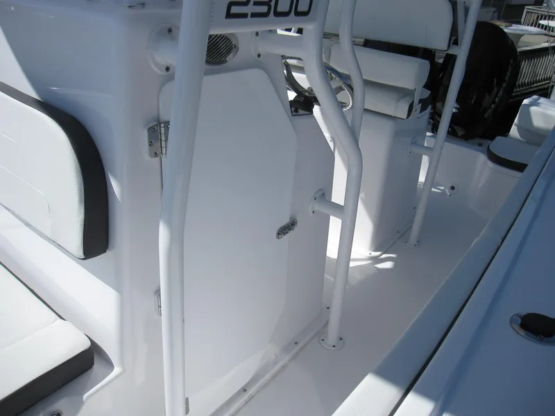 Slide: The Image of 2023 Clearwater 2300 boat interior with white seating and storage compartments. - 15