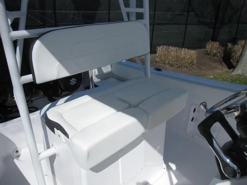 Slide: The Image of 2023 Clearwater 2300 boat with white cushioned seating and steering console. - 19