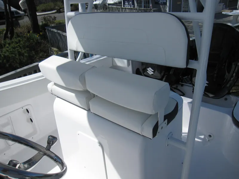 Slide: The Image of 2023 Clearwater 2300 boat with white cushioned seating and steering wheel. - 17