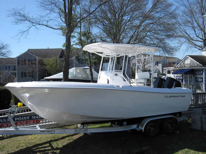 Slide: The Image of 2023 Clearwater 2300 boat on a trailer in a residential area. - 2