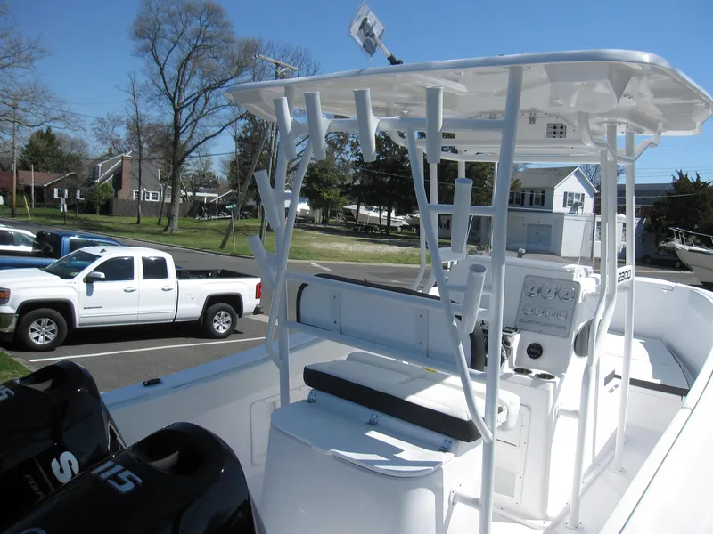 Slide: The Image of 2023 Clearwater 2300 boat with dual outboard motors and T-top in a residential area. - 26