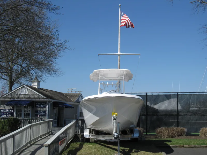Slide: The Image of 2023 Clearwater 2300 boat on trailer with American flag in marina. - 4
