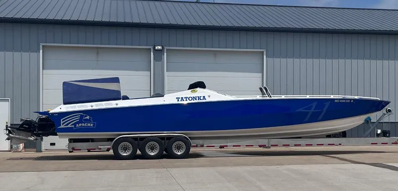 The Image of 1994 Apache 41 speedboat on a trailer in front of a warehouse. - 0