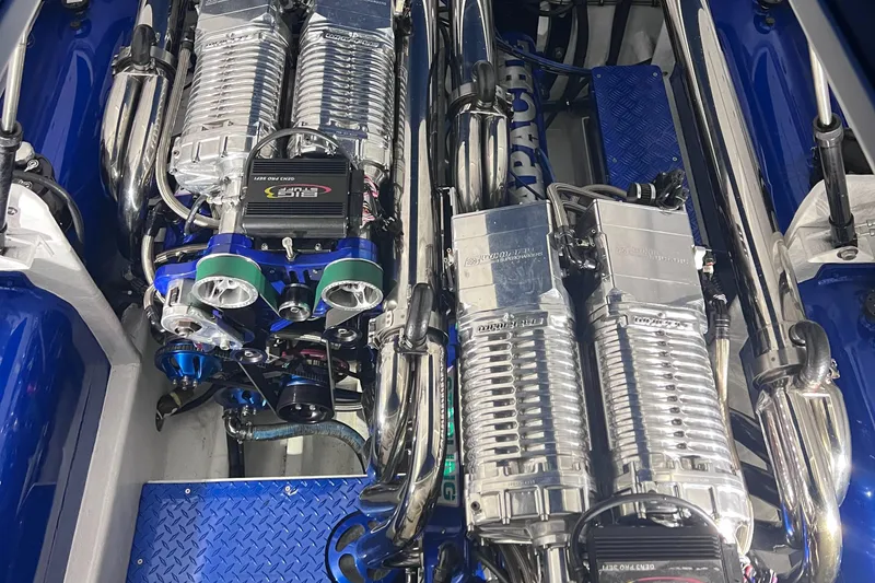 Slide: The Image of Twin engines of a 1994 Apache 41 boat with chrome detailing. - 10