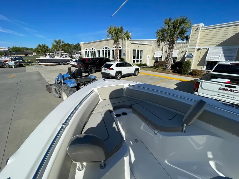 Slide: The Image of 2024 Key West 239 FS boat at a dealership with palm trees and vehicles. - 16