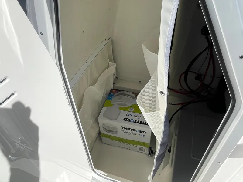 Slide: The Image of Storage compartment in 2024 Key West 239 FS boat with Thetford portable toilet. - 18