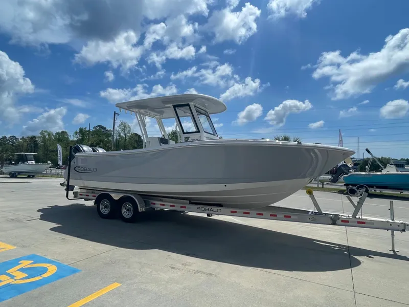 Slide: The Image of 2023 Robalo 270 boat on a trailer under a clear blue sky. - 1