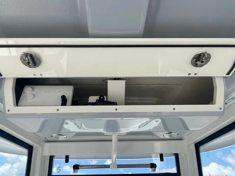 Slide: The Image of 2023 Robalo 270 boat overhead storage compartment with open hatch. - 18