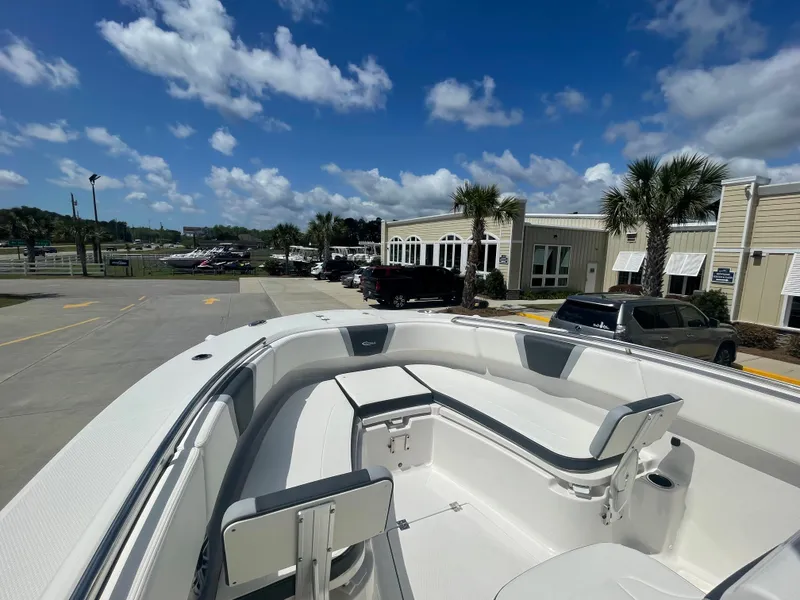 Slide: The Image of 2023 Robalo 270 boat with spacious seating, docked at a marina under a clear blue sky. - 20