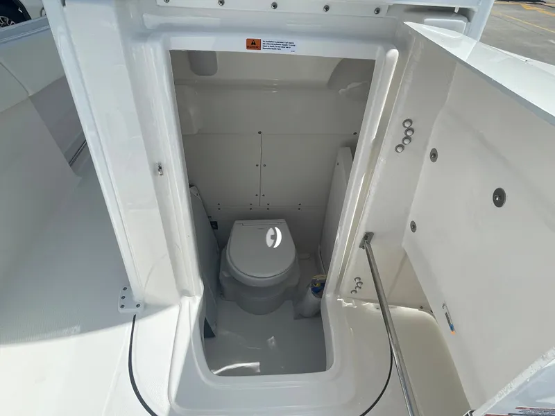 Slide: The Image of 2023 Robalo 270 boat interior with a compact marine toilet. - 22