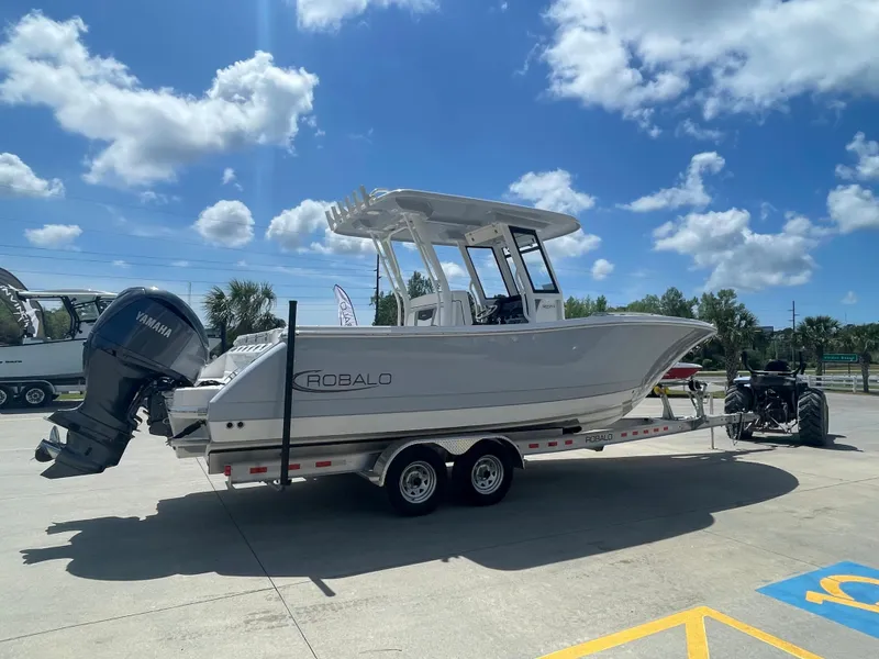 Slide: The Image of 2023 Robalo 270 boat on a trailer under a bright blue sky. - 6