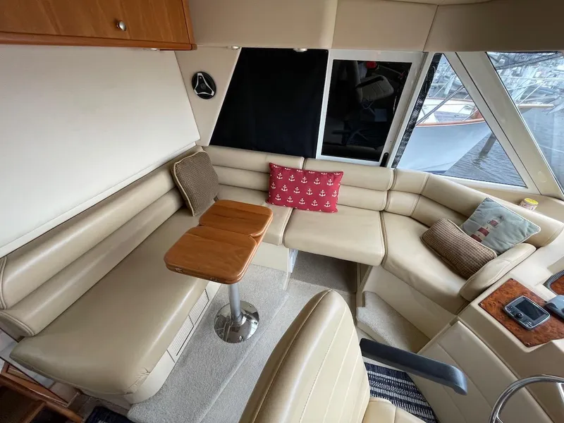 Slide: The Image of Luxurious 2004 Meridian 490 Pilothouse interior with beige leather seating and wooden table. - 20