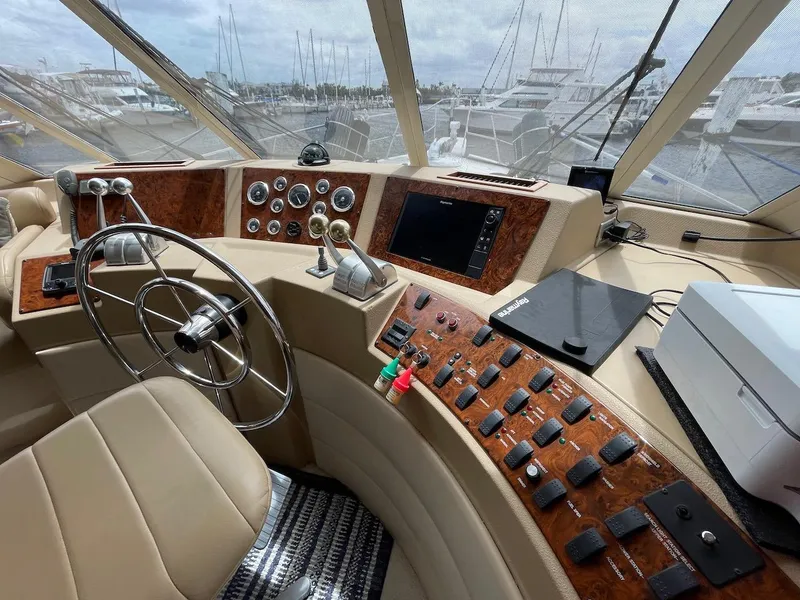 Slide: The Image of 2004 Meridian 490 Pilothouse helm with steering wheel, controls, and navigation equipment. - 26