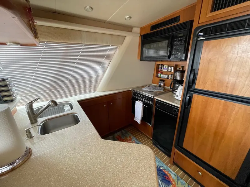 Slide: The Image of 2004 Meridian 490 Pilothouse kitchen with modern appliances and wood cabinetry. - 32
