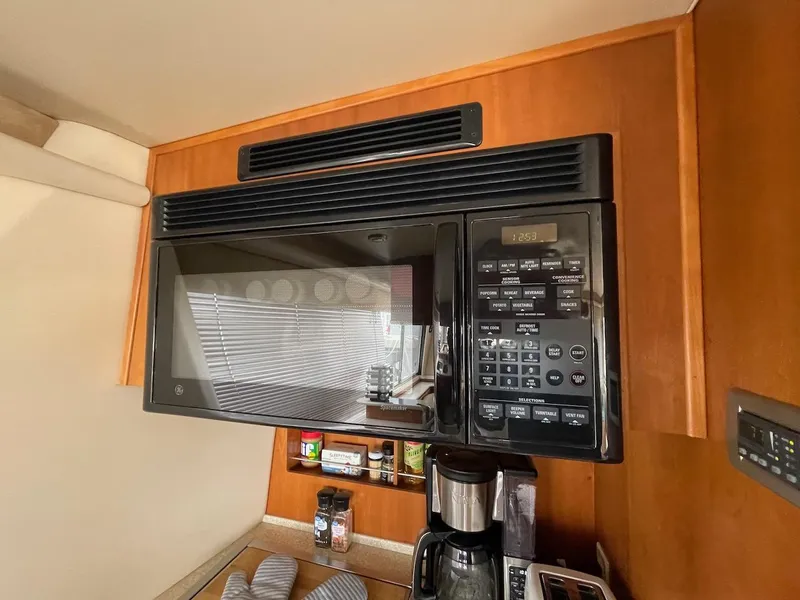 Slide: The Image of Microwave in 2004 Meridian 490 Pilothouse kitchen with wooden cabinetry. - 35