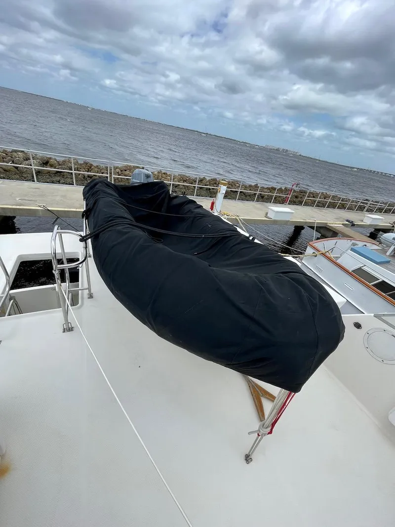 Slide: The Image of 2004 Meridian 490 Pilothouse yacht with covered equipment on deck, docked by the sea. - 9