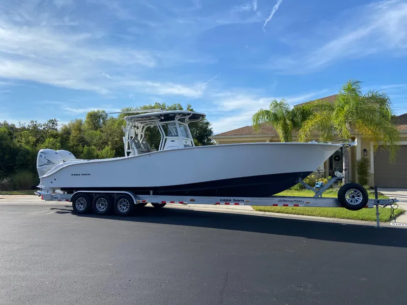 Slide: The Image of 2022 Cape Horn 34 XS boat on a trailer, parked on a residential street. - 14
