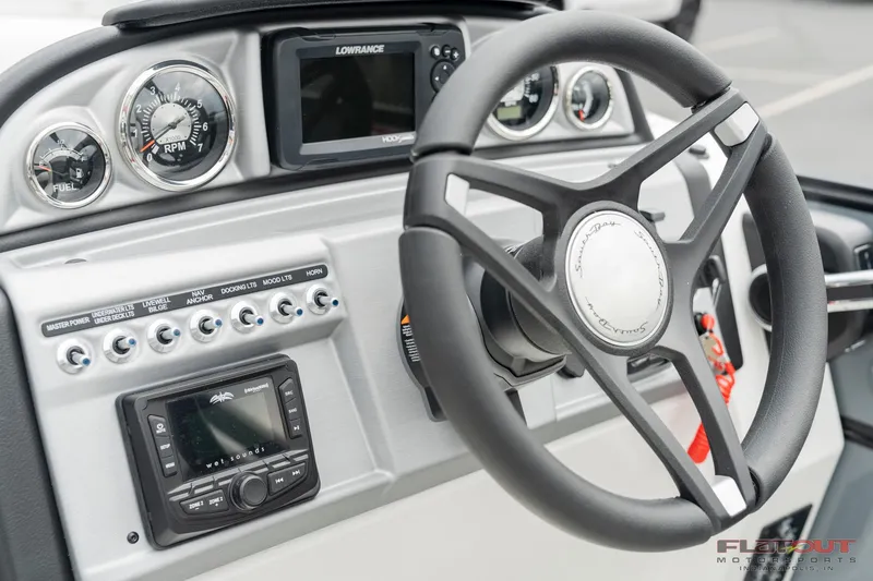 Slide: The Image of 2023 South Bay S224 Universal Lounge 200HP boat dashboard with steering wheel and control panel. - 12
