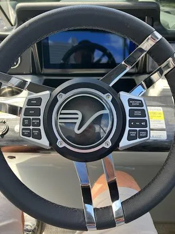 Slide: The Image of Steering wheel of a 2023 Vanderbilt 700T boat with control buttons. - 10