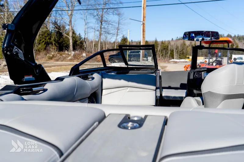 Slide: The Image of 2022 Centurion Fi23 boat interior with sleek seating and open windshield, outdoors. - 10