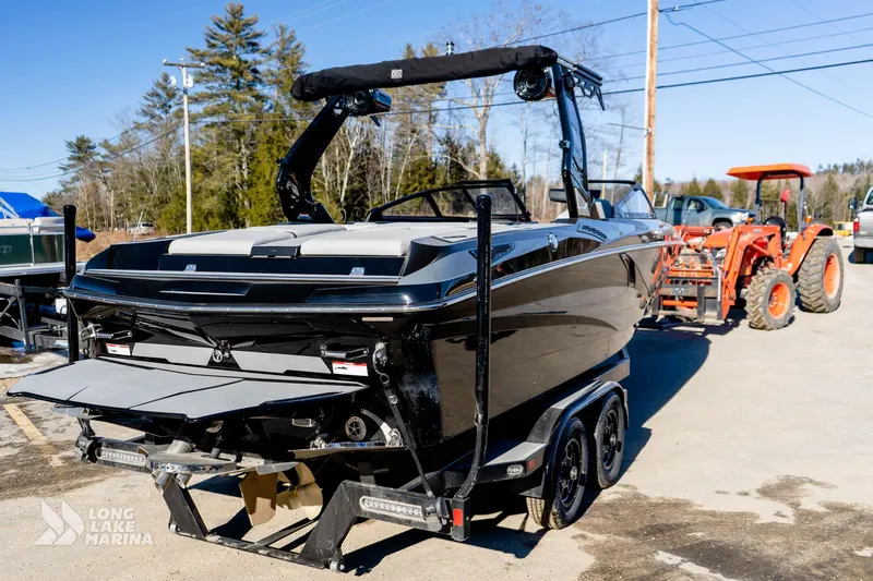 Slide: The Image of 2022 Centurion Fi23 boat on trailer at Long Lake Marina, with tractor in background. - 2